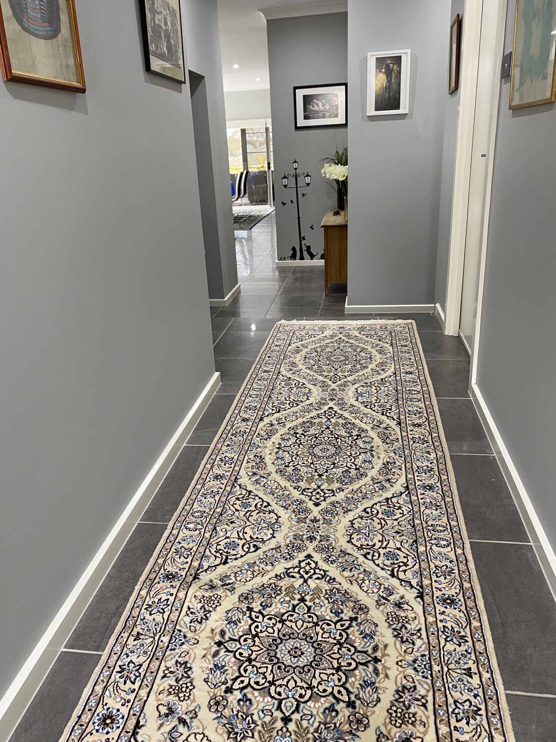 An image of a modern living room with a Persian rug as the focal point. The rug features a bold geometric pattern in shades of blue and white, complementing the neutral-colored furniture and decor in the room. The rug adds a pop of color and interest to the space while creating a cozy and inviting atmosphere.