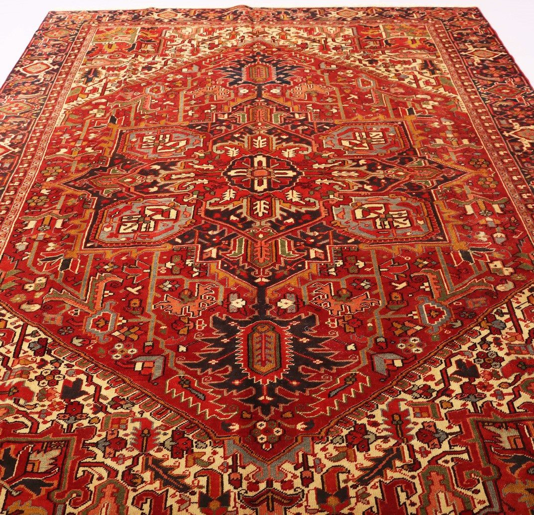 Persian rug made of high-quality materials displayed in a workshop with skilled artisans working in the background.