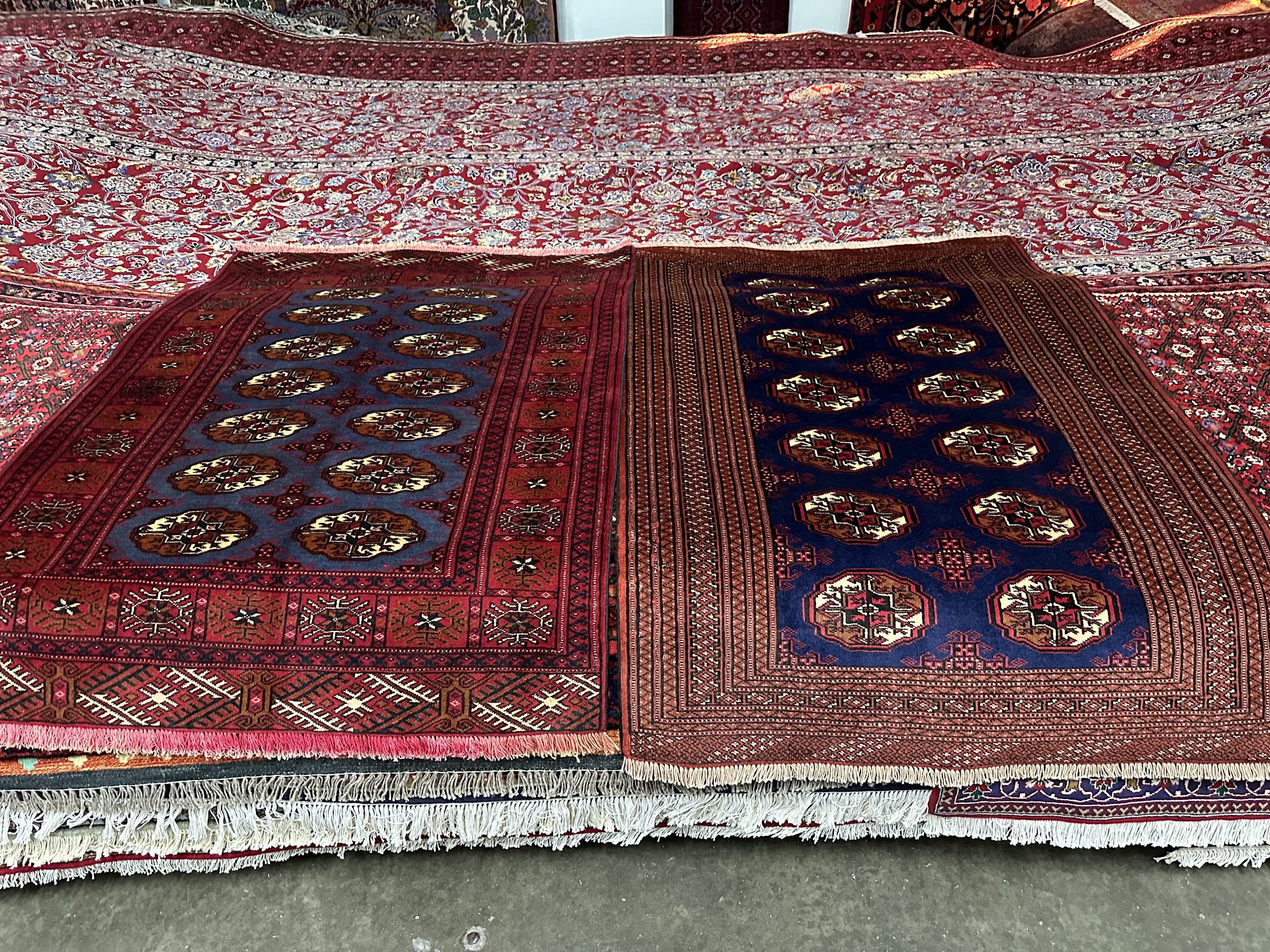 A close-up view of a Persian rug showcasing its intricate patterns and a symphony of rich, vibrant colors. The rug's motifs and symbols tell a captivating story through shades and design elements. Whether bold and tribal or elegantly floral, RugMaster's diverse collection caters to various preferences. Meticulously handcrafted with premium materials, these rugs offer both visual appeal and long-lasting durability.